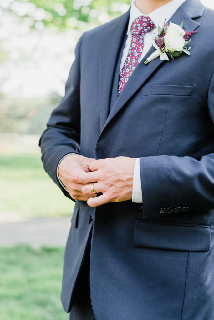 Navy blue groom’s suit with floral pink tie by Jenn Kavanagh Photography