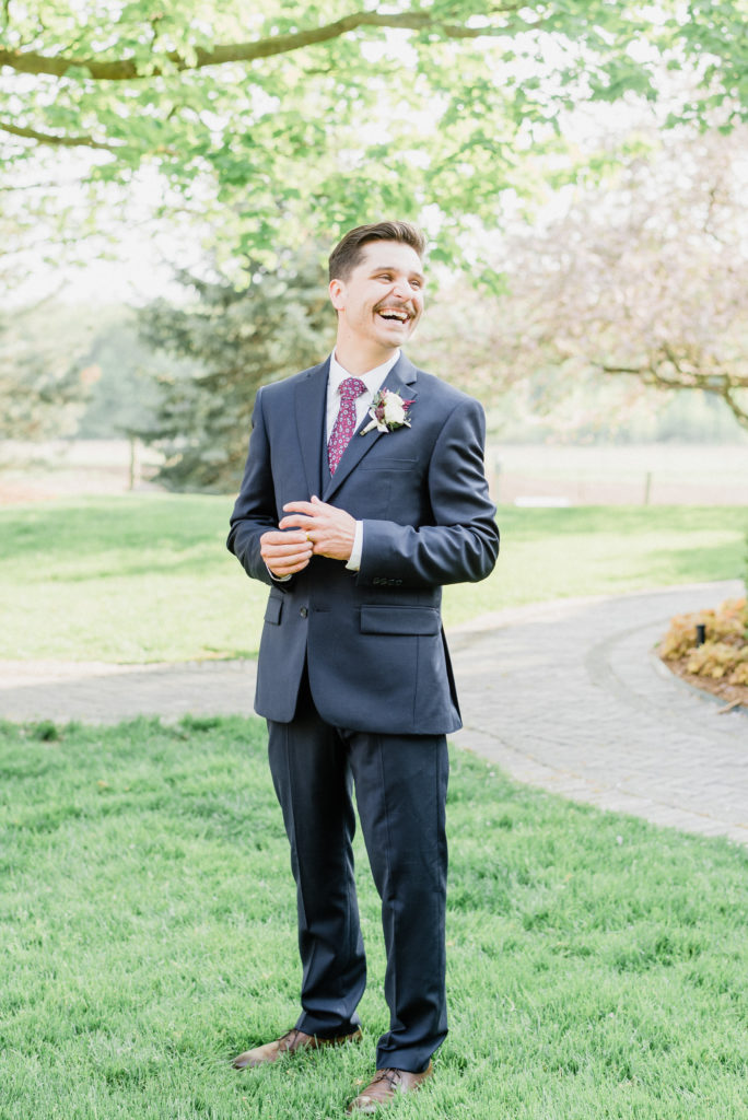 Navy blue groom’s suit with floral pink tie by Jenn Kavanagh Photography